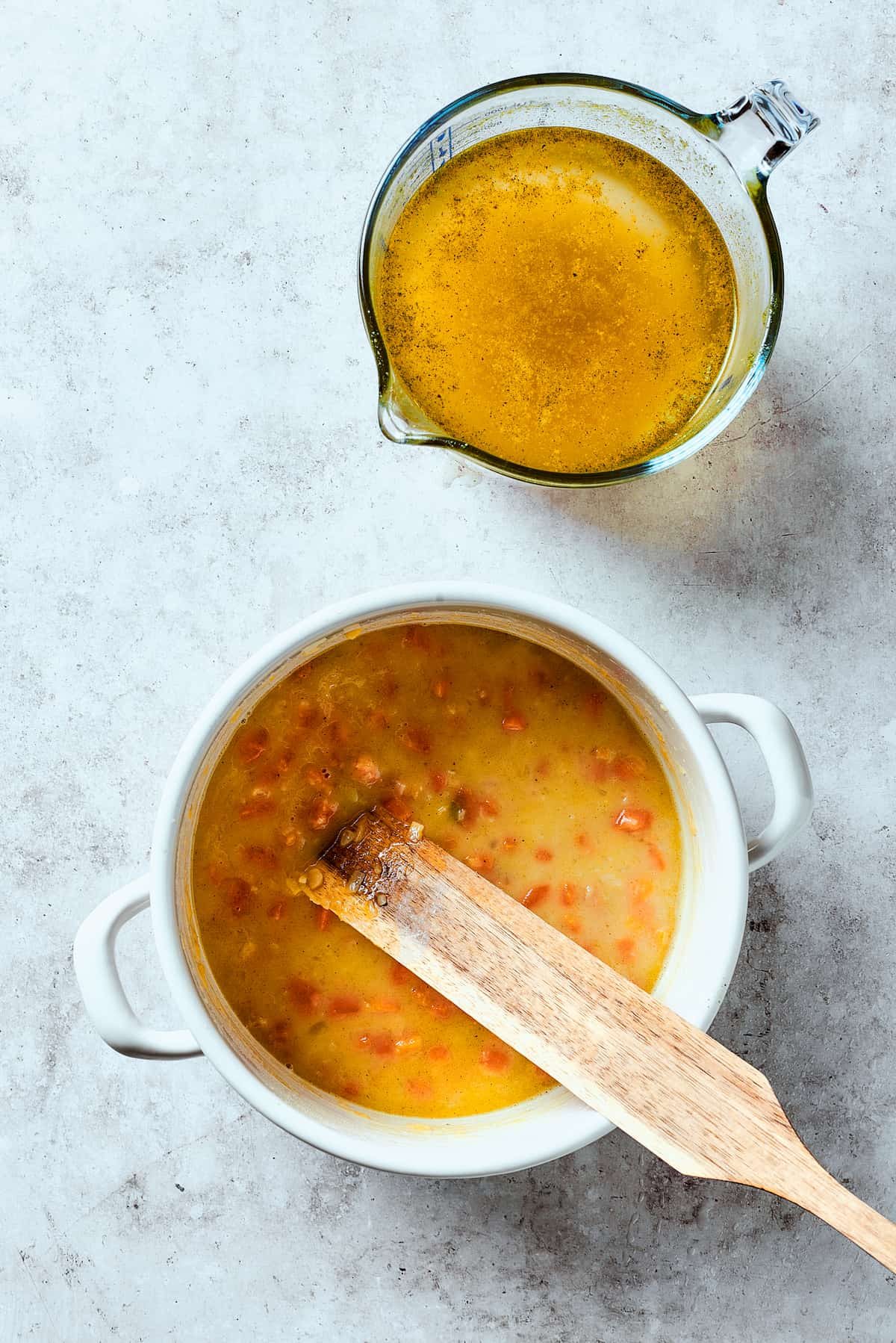 Adding broth to a soup pot.