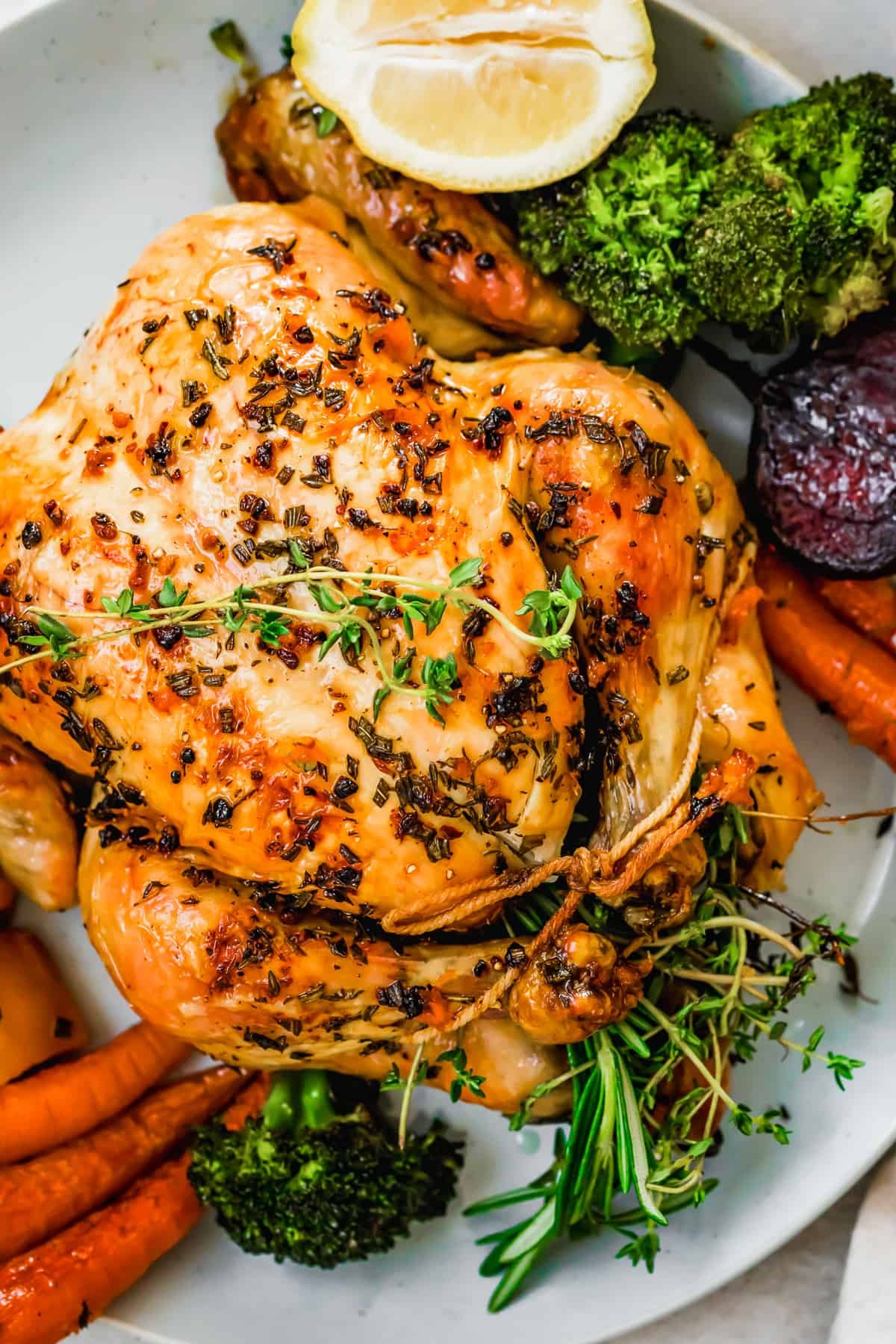 overhead close up shot of whole roast chicken served on a platter.