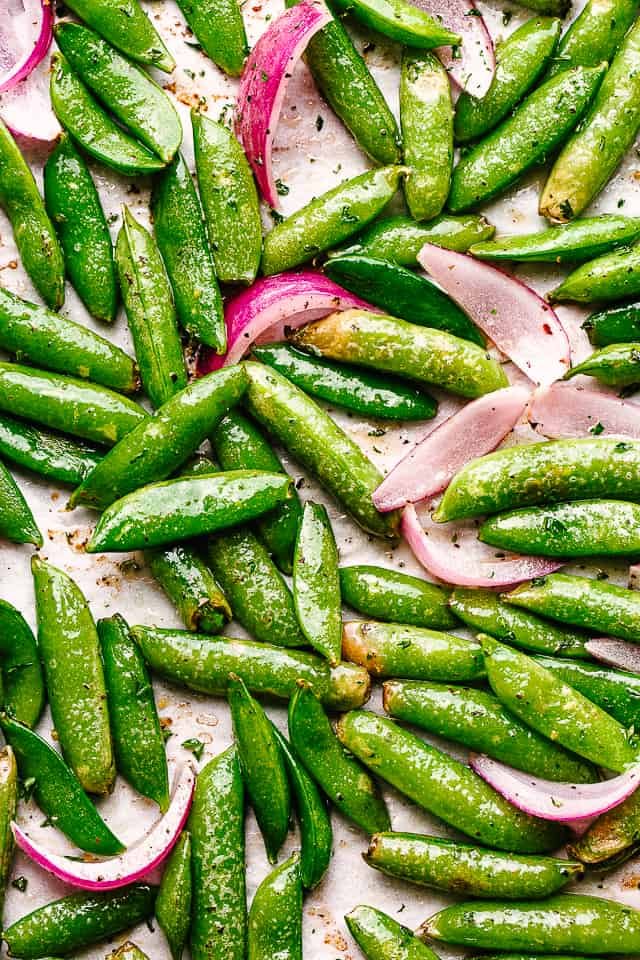 top view of roasted sugar snap peas and sliced red onions