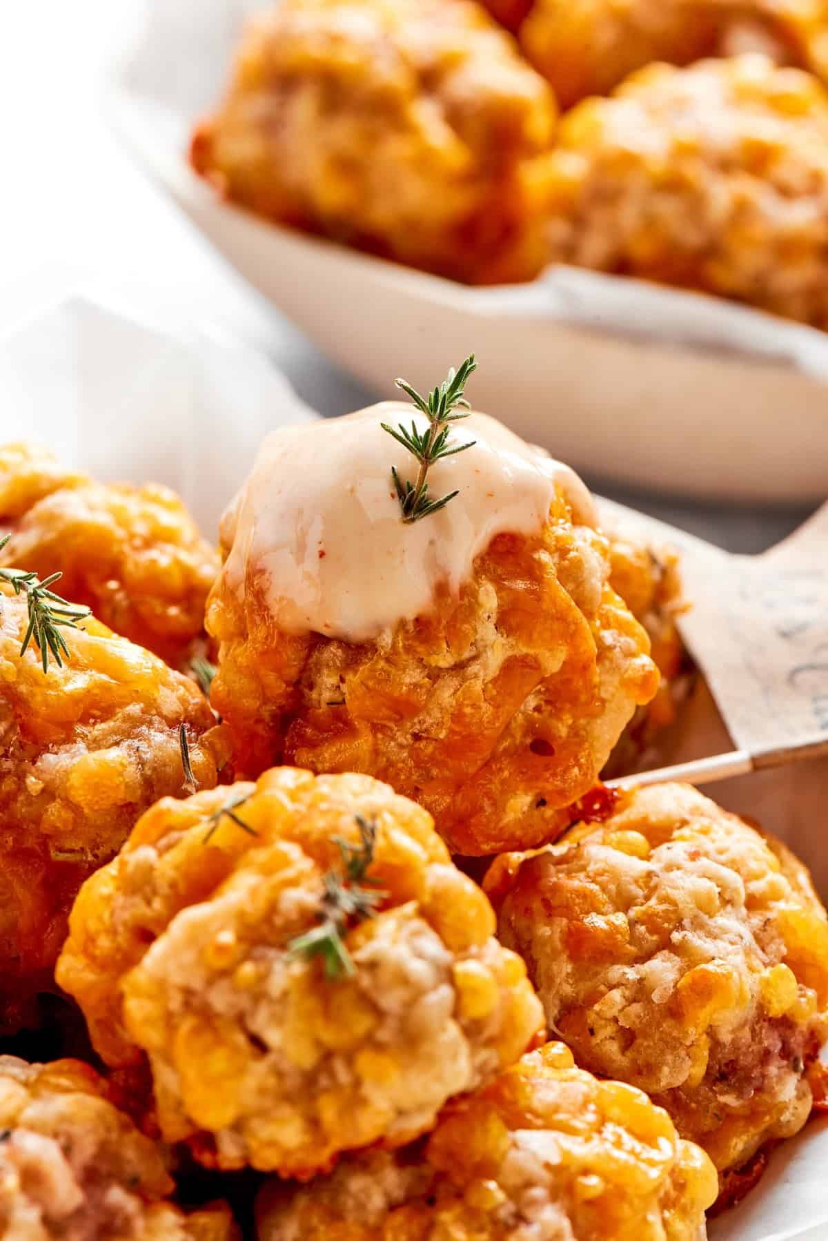 Dipping sauce tops a sausage ball.