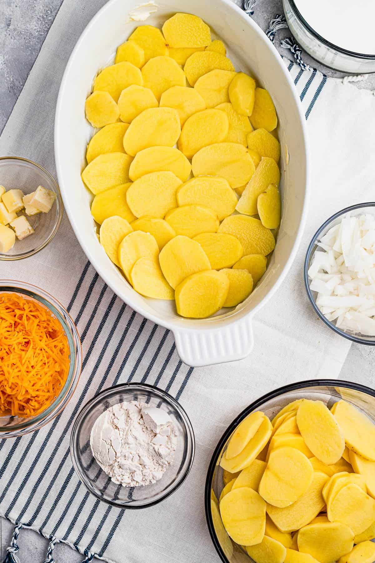 Sliced potatoes layered in a baking dish.