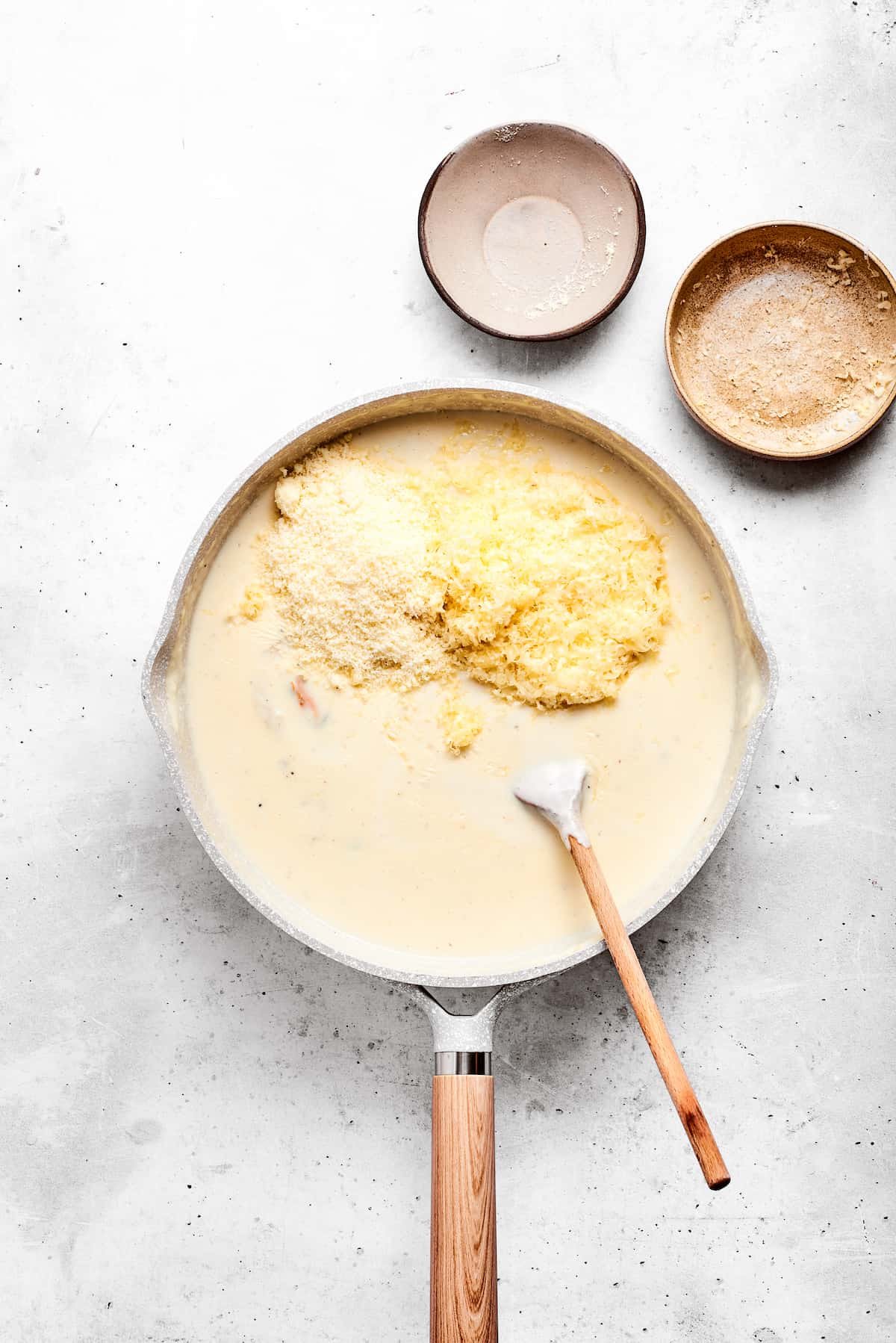 Adding cheese to the sauce base.