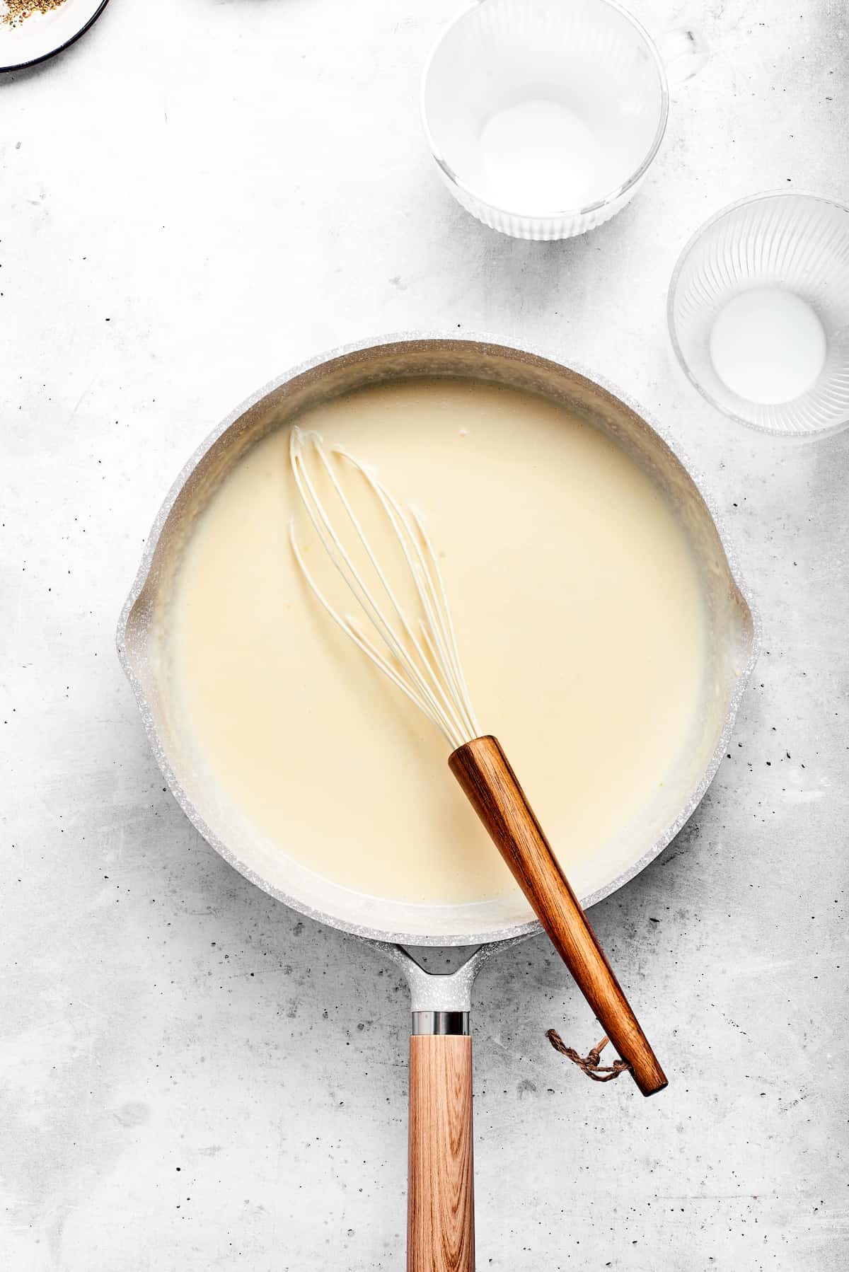 Adding milk to the mixture.