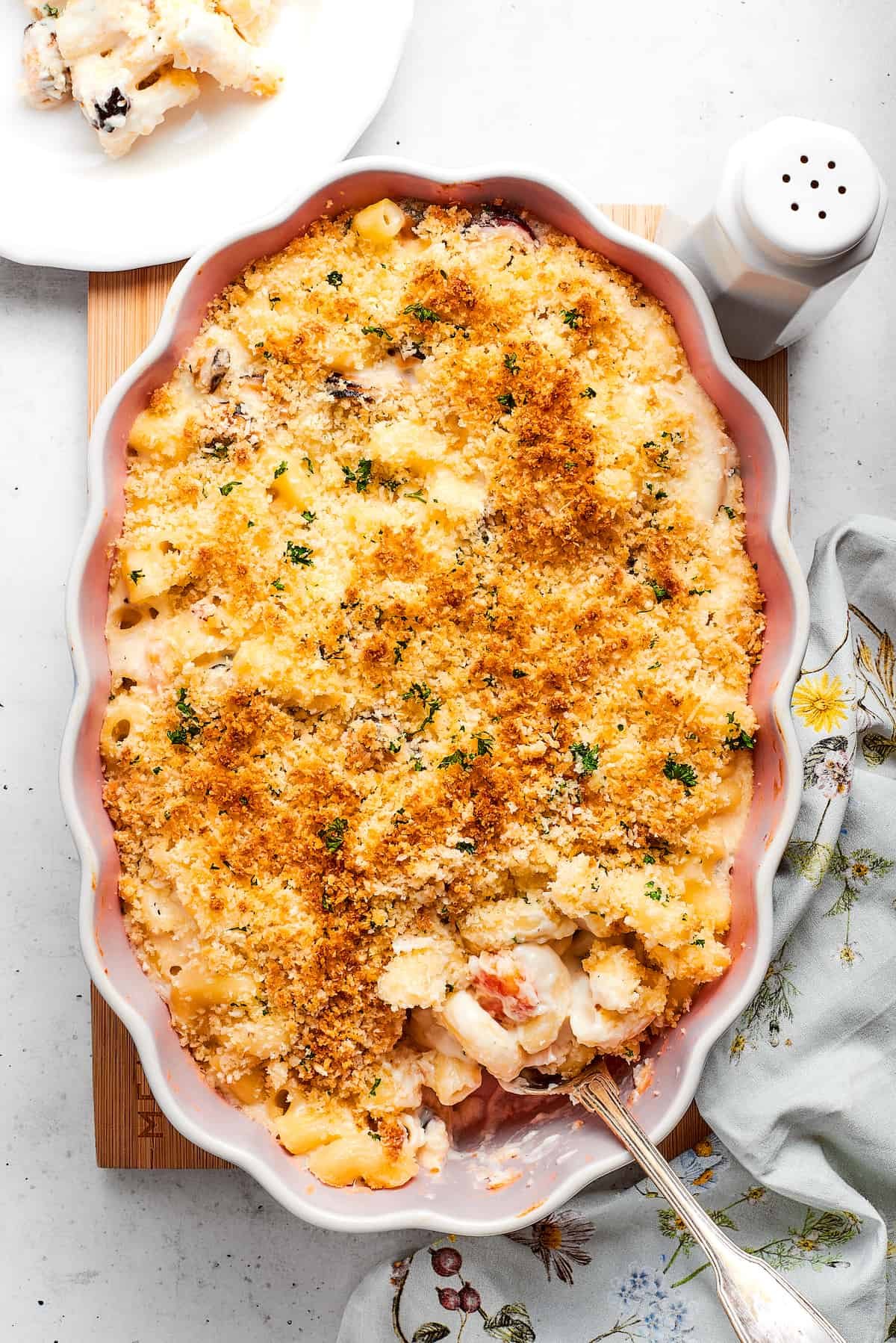 Cooked Seafood mac and cheese with a serving spoon ready to take some out.