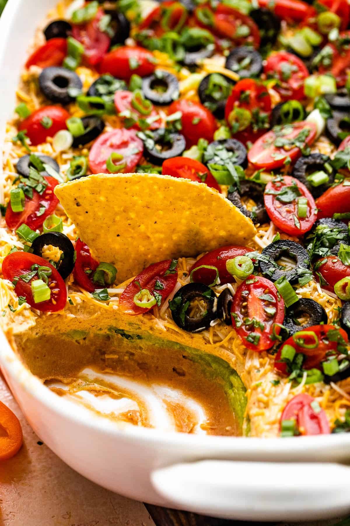 side shot of a white baking dish with seven layer mexican dip