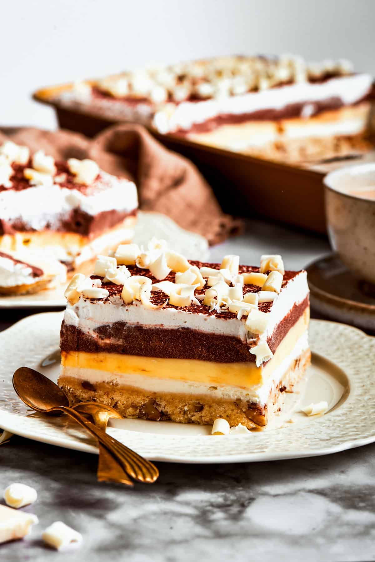This easy Sex in a Pan recipe layers a tangy-sweet cream cheese filling with vanilla and chocolate puddings on top of a pecan crust.