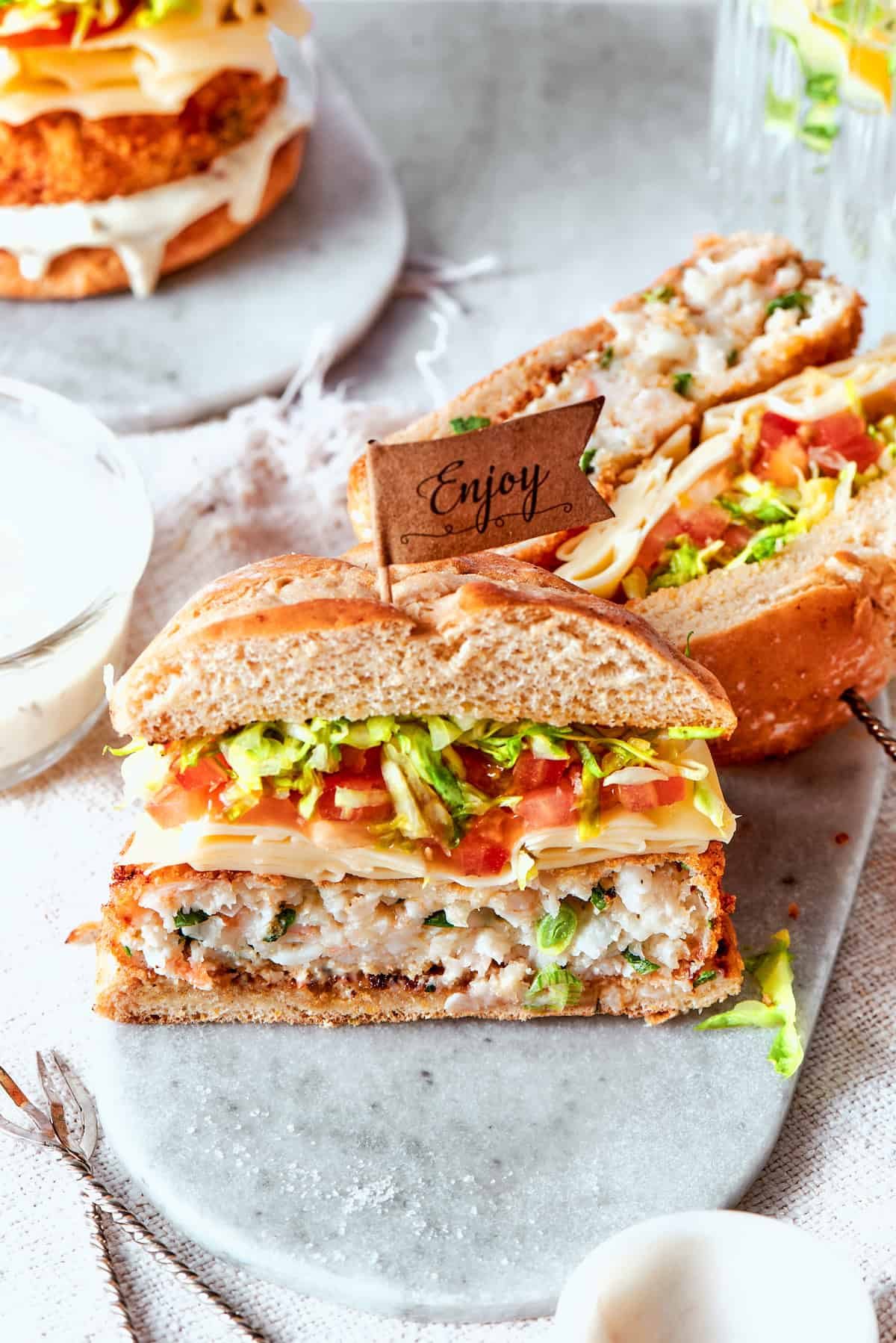 Shrimp burgers are cut in half and served to show their interiors.