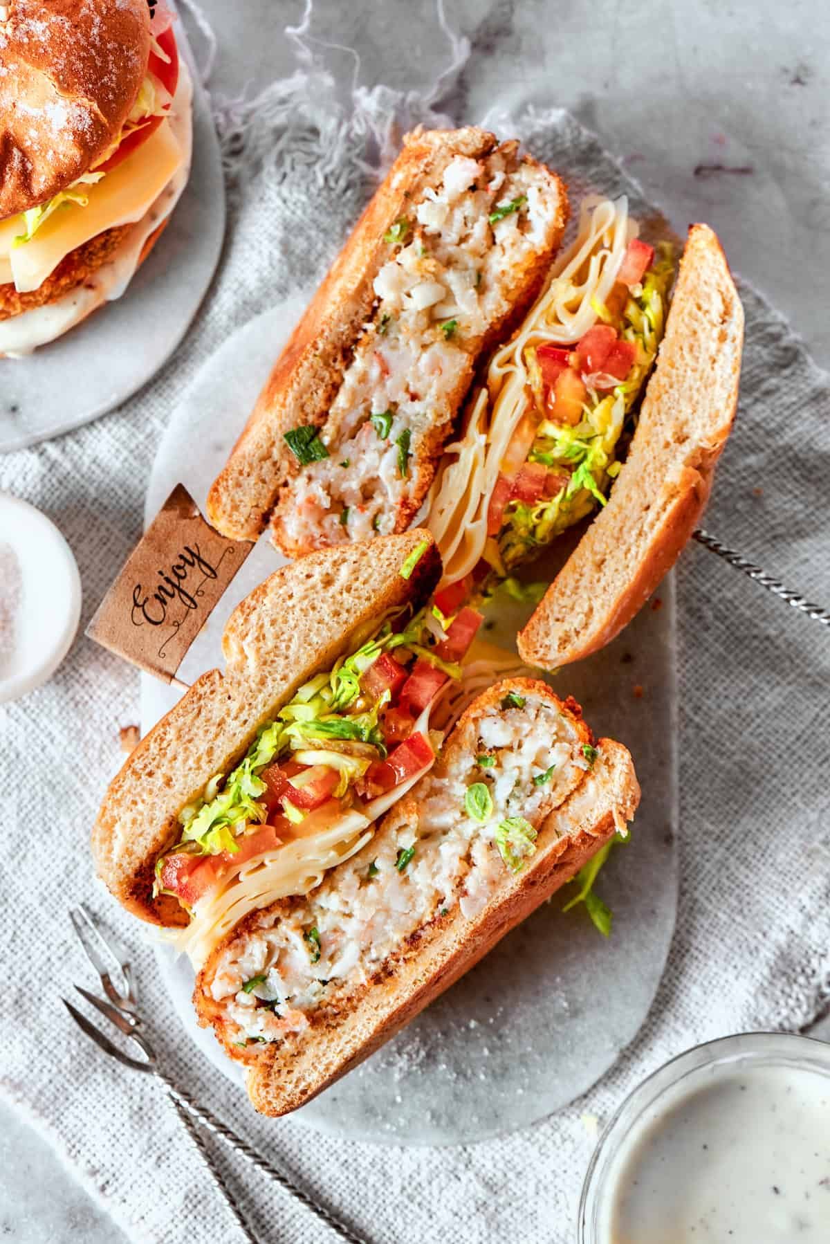 Two shrimp burger halves are turned on their sides.