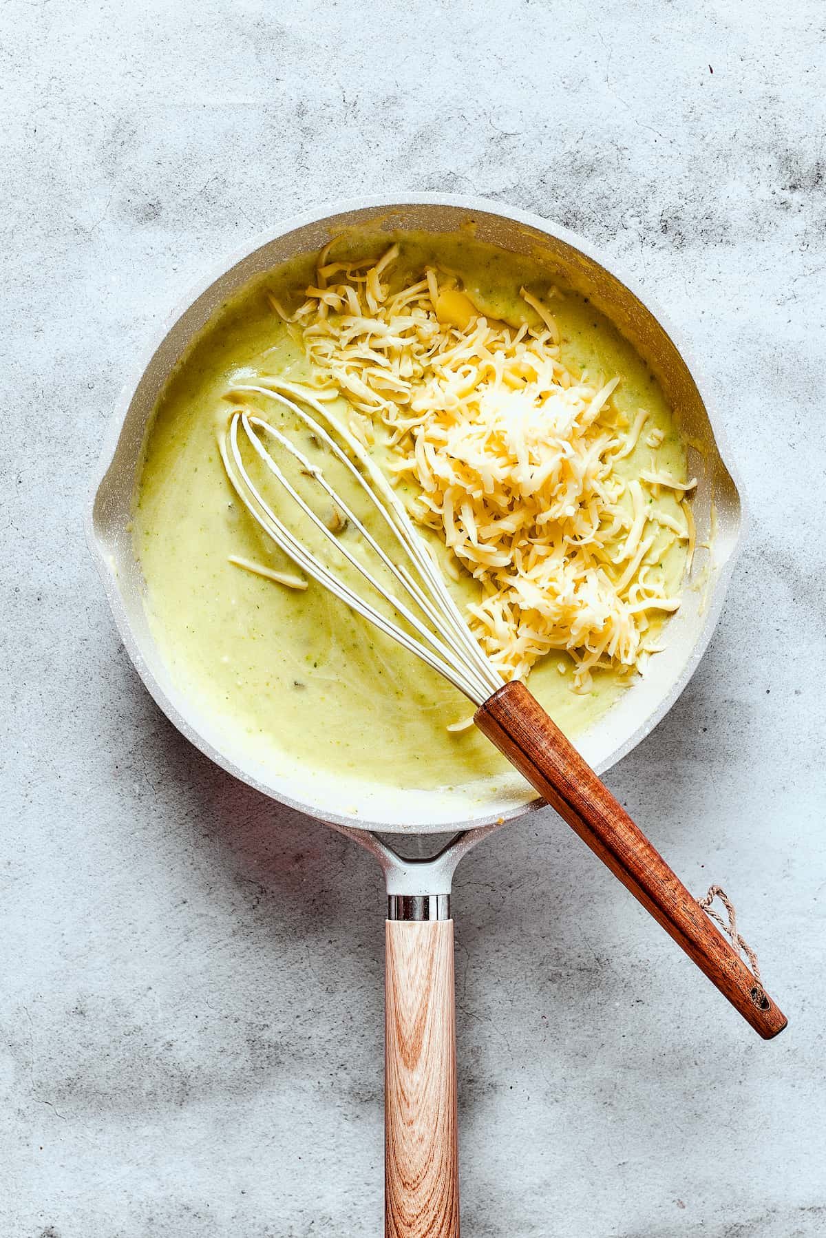 Whisking cheese into enchilada sauce.