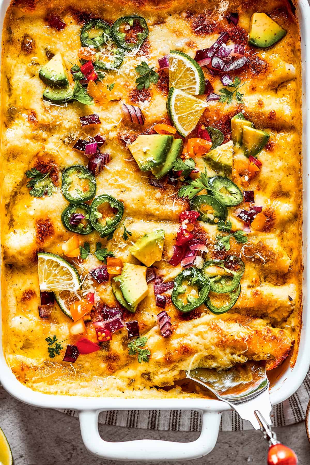 Photo of the bottom corner of a baking dish of homemade shrimp enchiladas.