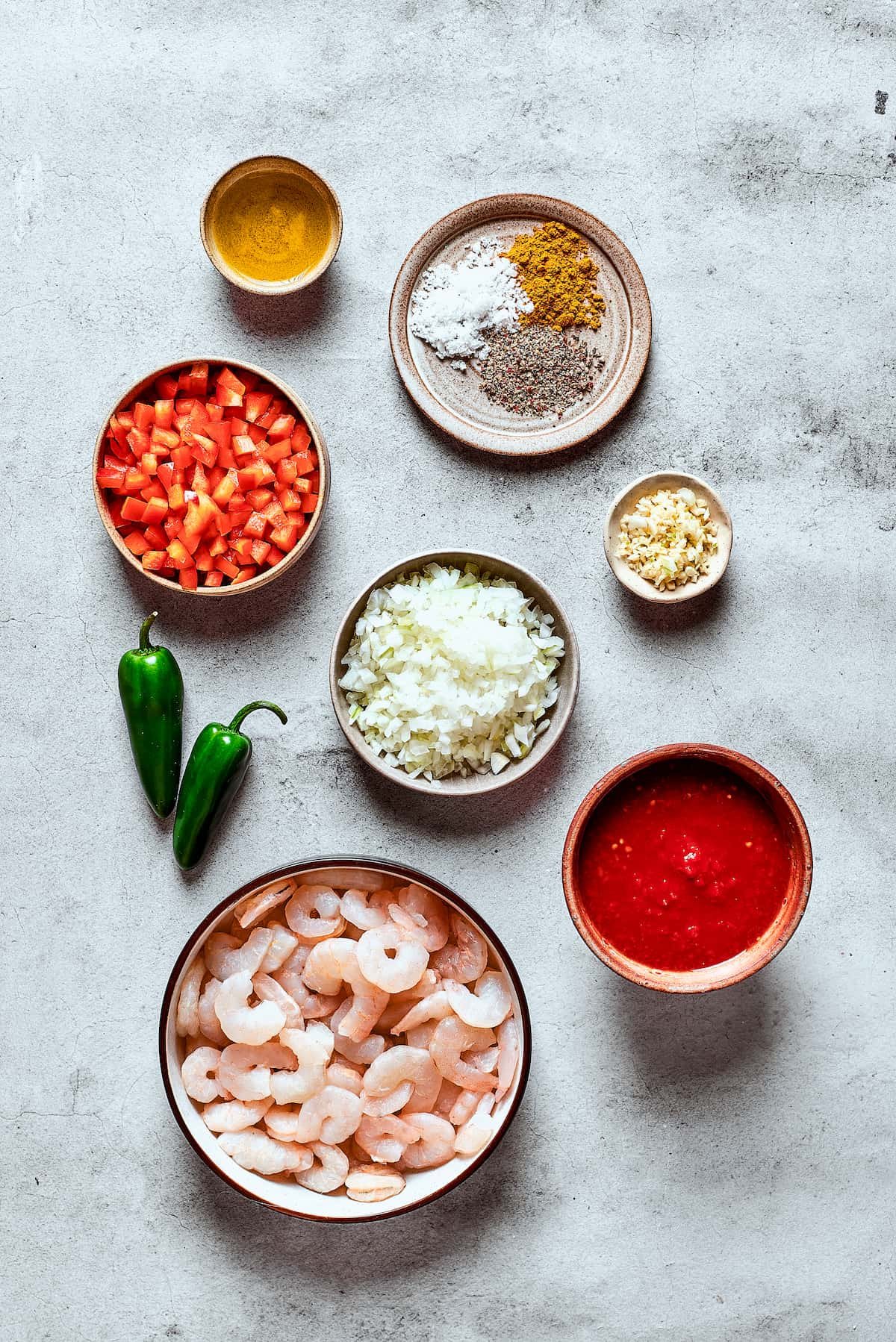 Ingredients for shrimp enchilada filling measured and arranged on a work surface.