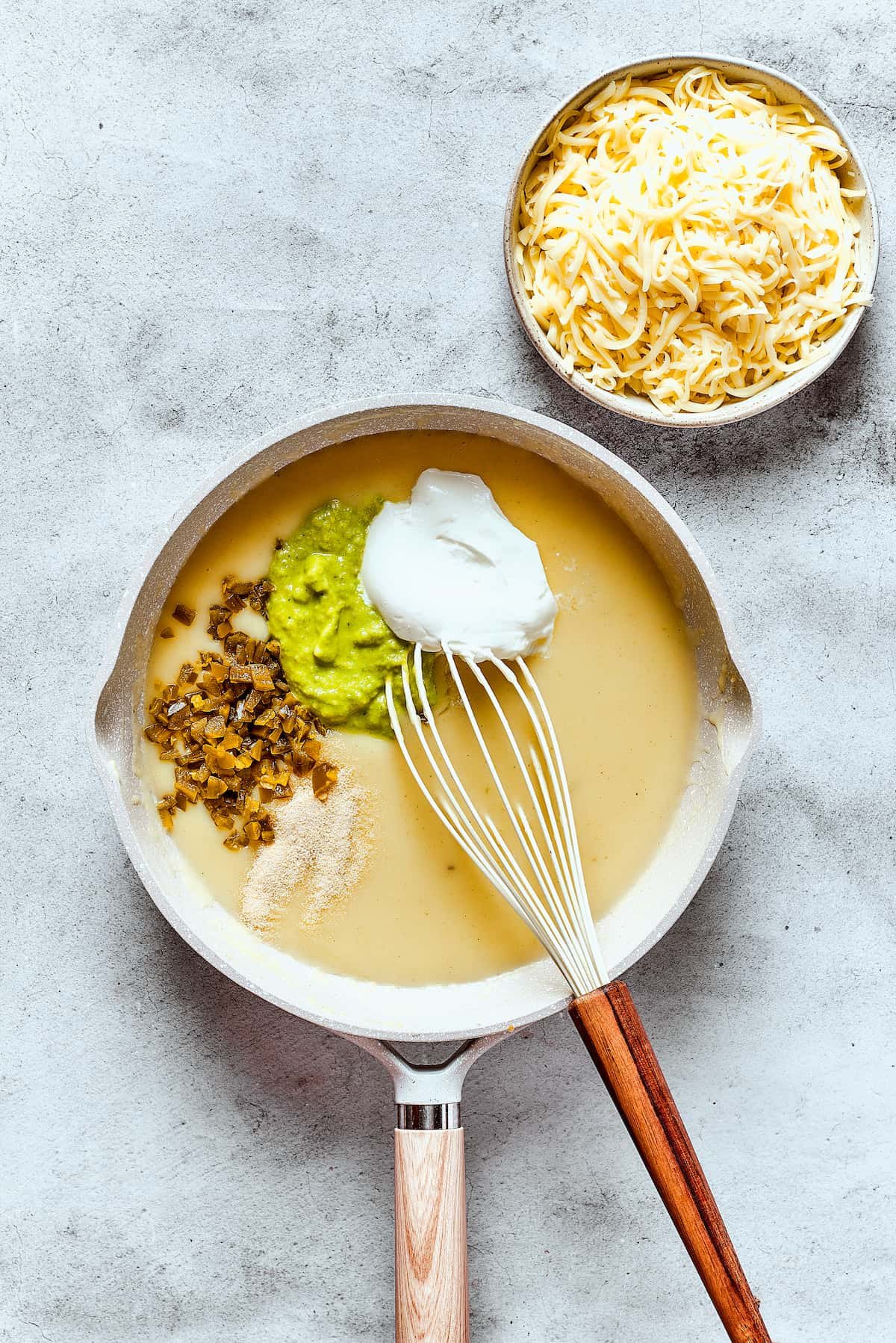 Making a creamy green enchilada sauce in a skillet.