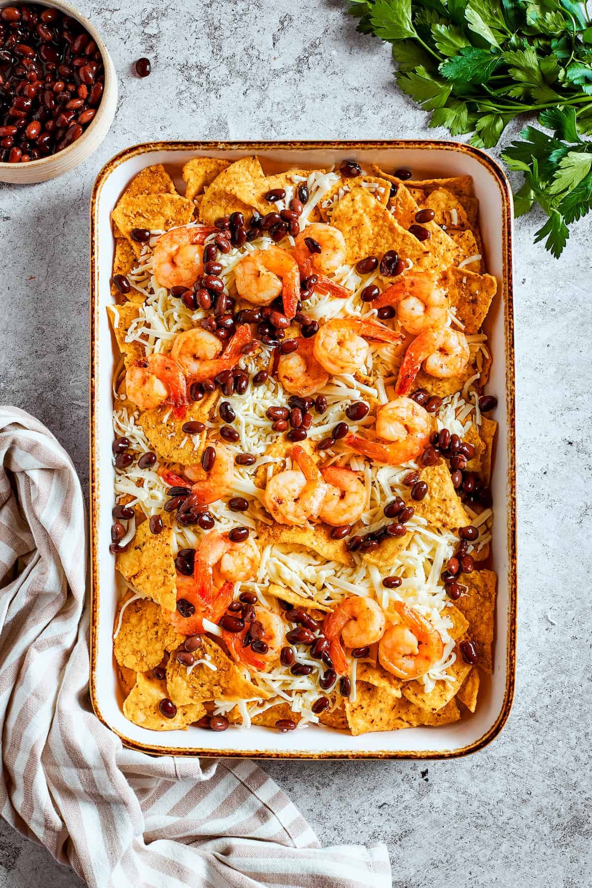 Toppings are scattered over the top of the nachos.