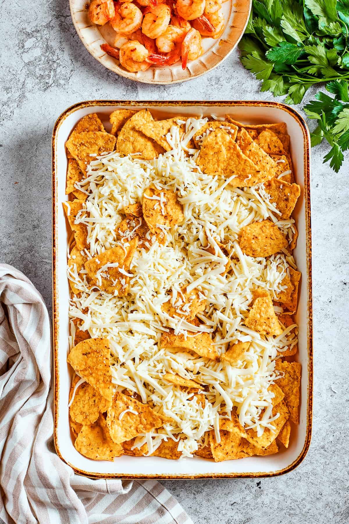 Shredded cheese is added to the nachos.
