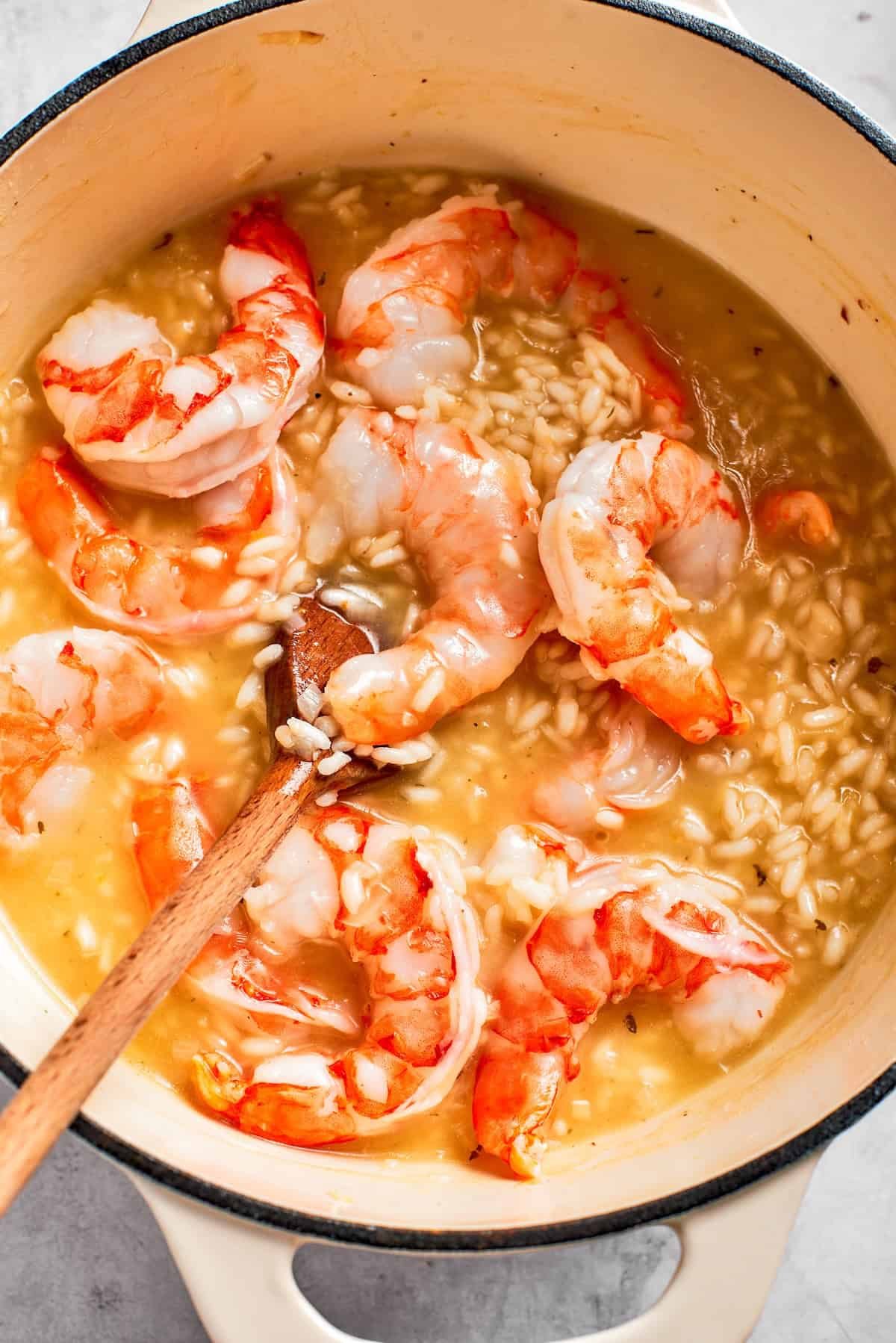 Shrimp cooks in a pot of risotto.