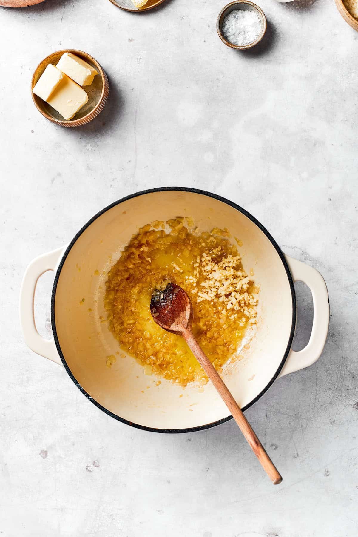 Stirring aromatics in a pot.