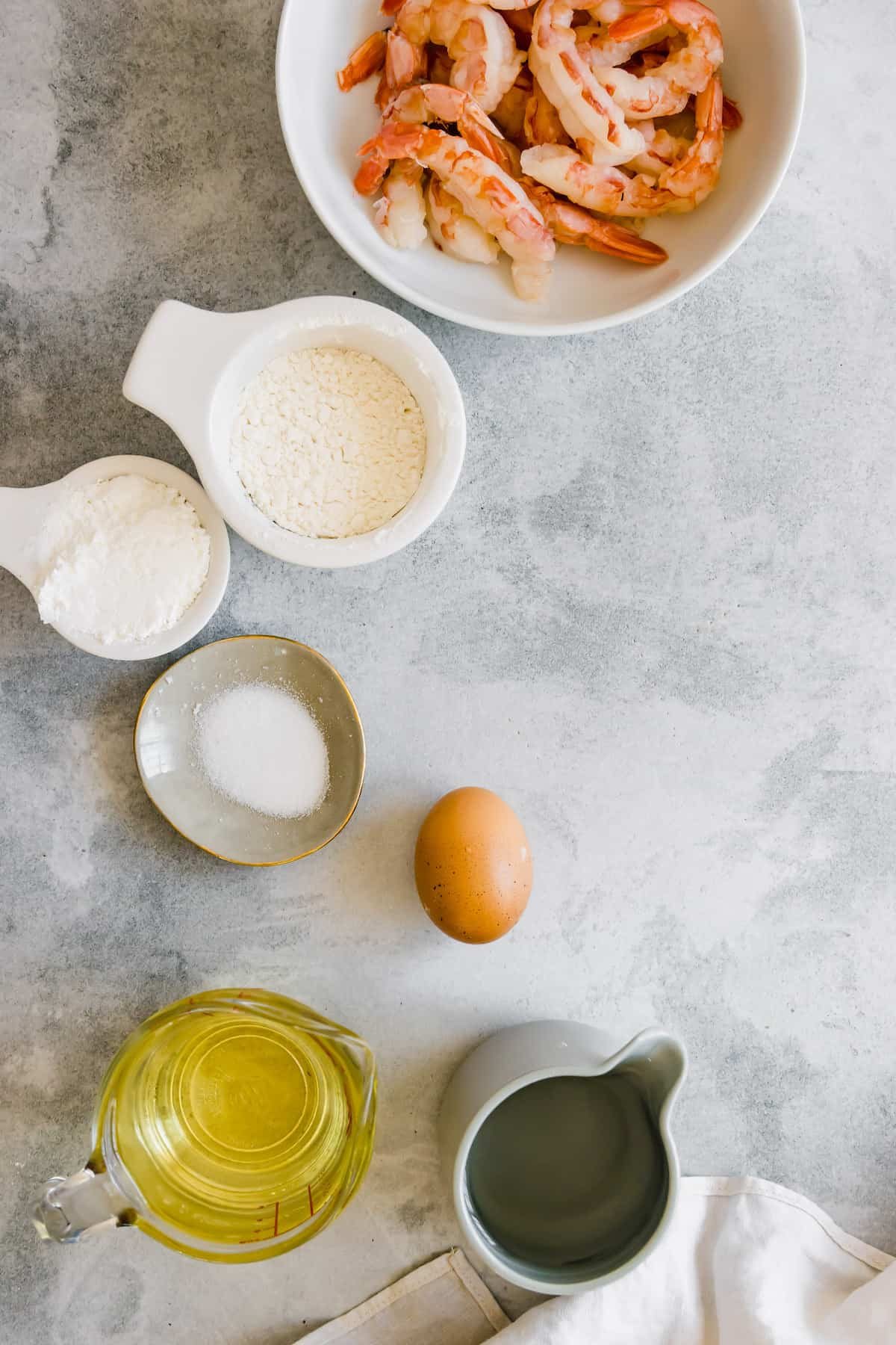 Oil, an Egg, Cornstarch, Salt and the Rest of the Shrimp Tempura Ingredients on a Countertop