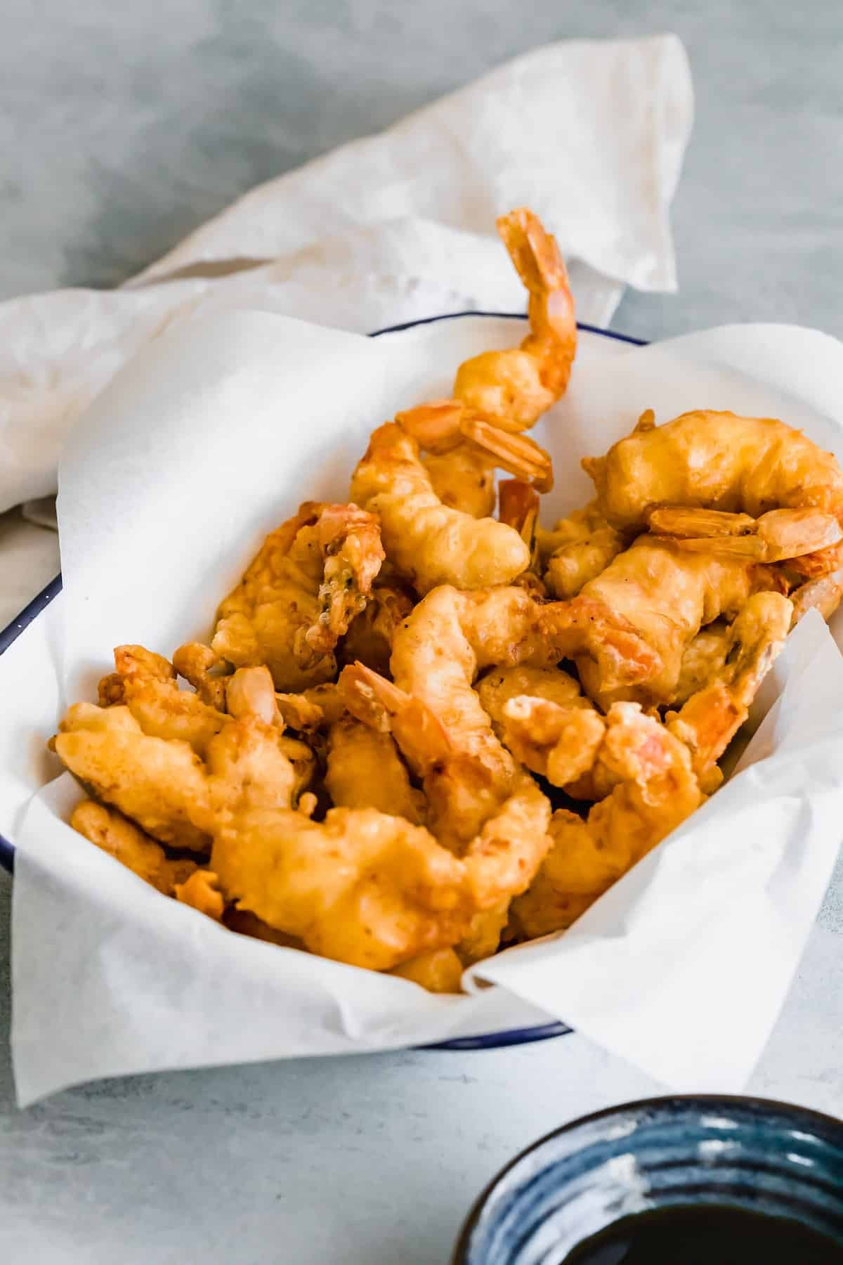 A Parchment-Lined Serving Platter Containing Pan-Fried Shrimp Tempura