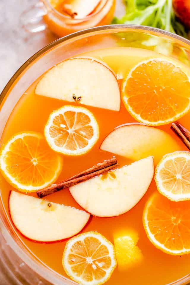 overhead close up shot of apple cider punch in a punch bowl with slices of fruit floating on top