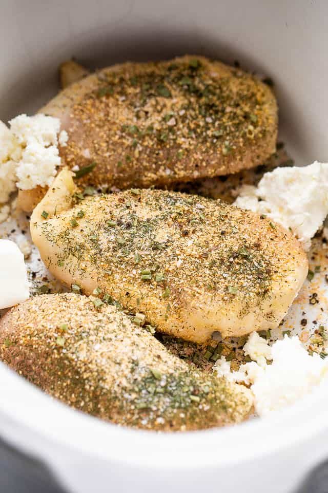 three seasoned raw chicken breasts