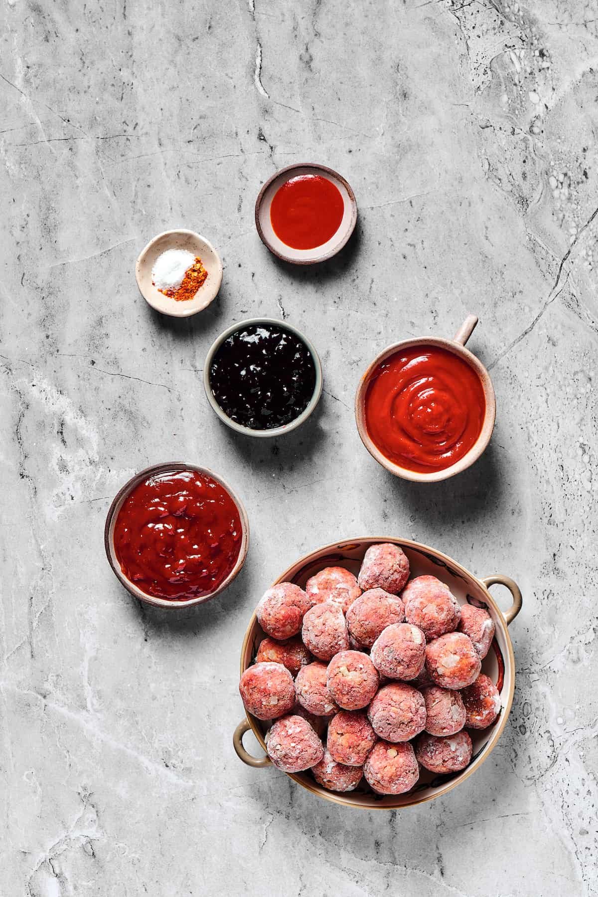 From top: Seasonings, sriracha, grape jelly, ketchup, barbecue sauce, frozen meatballs.
