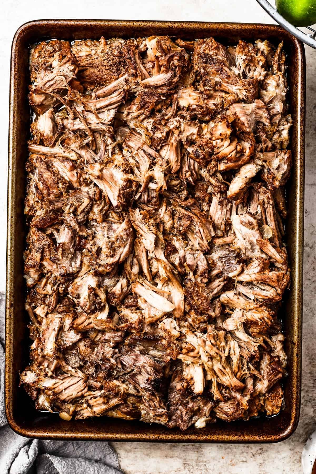Browned shredded pork on a baking sheet.