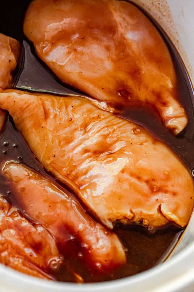 raw chicken breasts covered in barbecue sauce