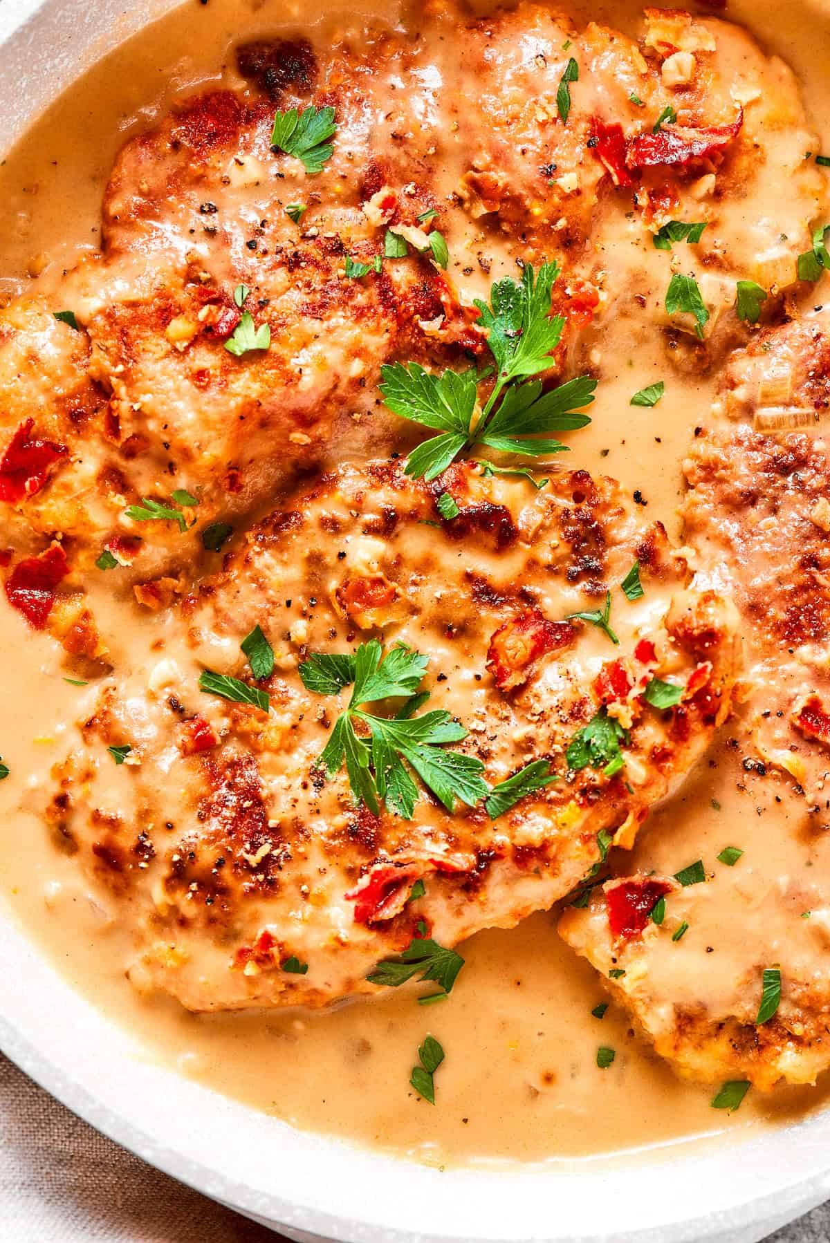 Parsley tops pieces of smothered chicken.