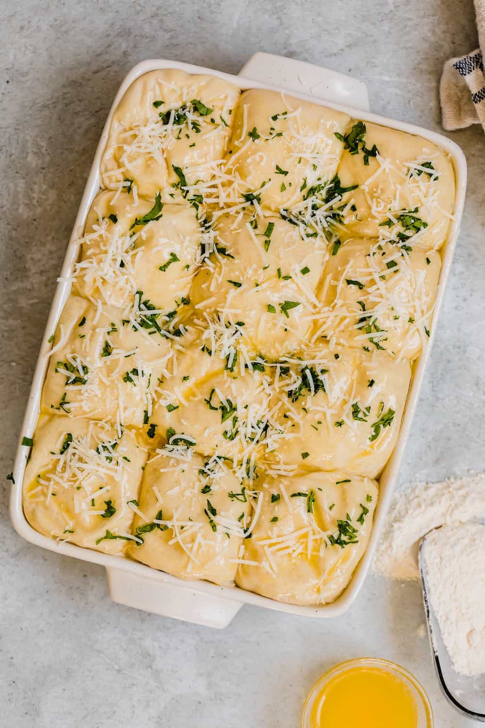 Risen Parmesan Dinner Roll Dough Topped with Parmesan Cheese and Chopped Parsley