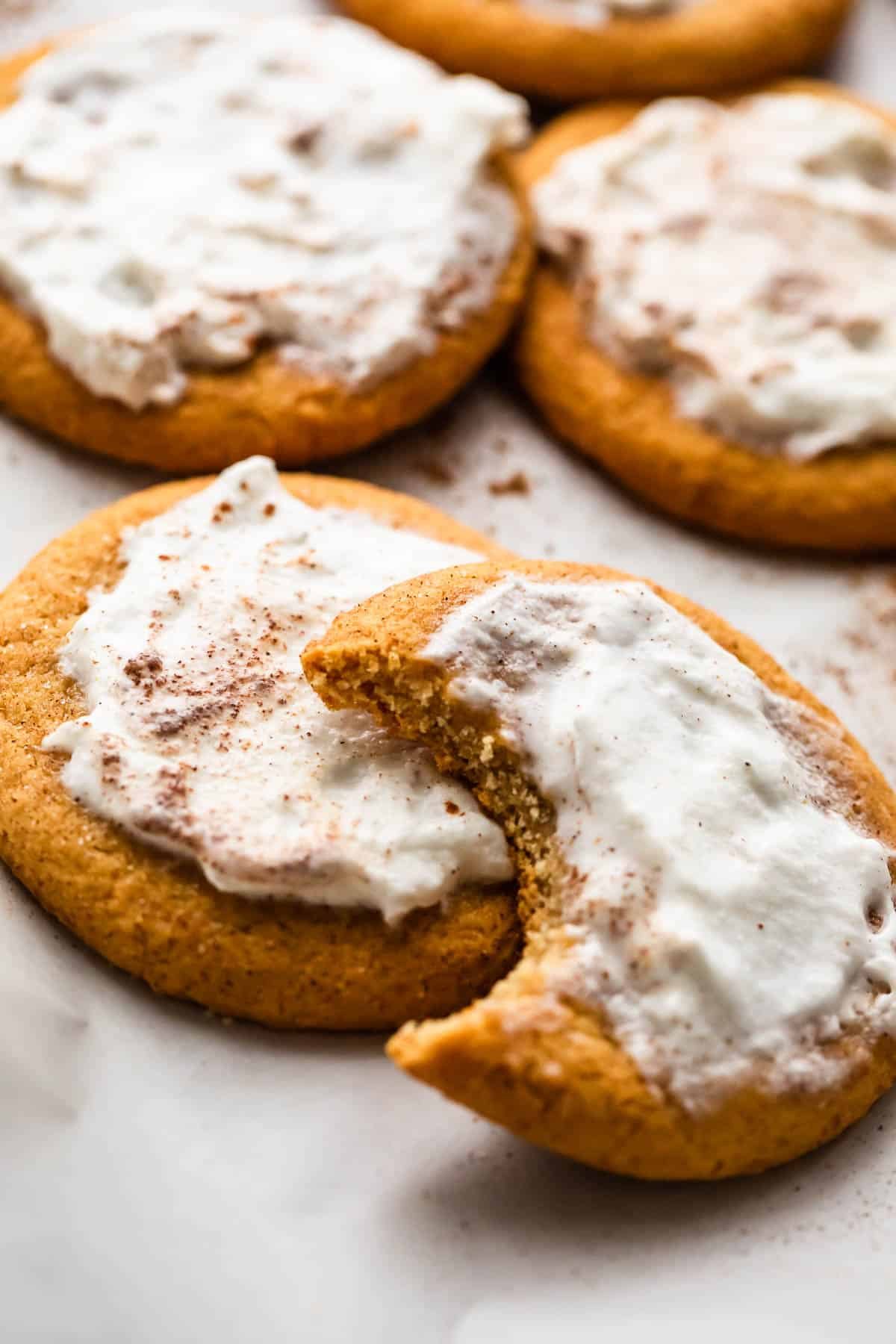 five frosted pumpkin cookies set on a white background