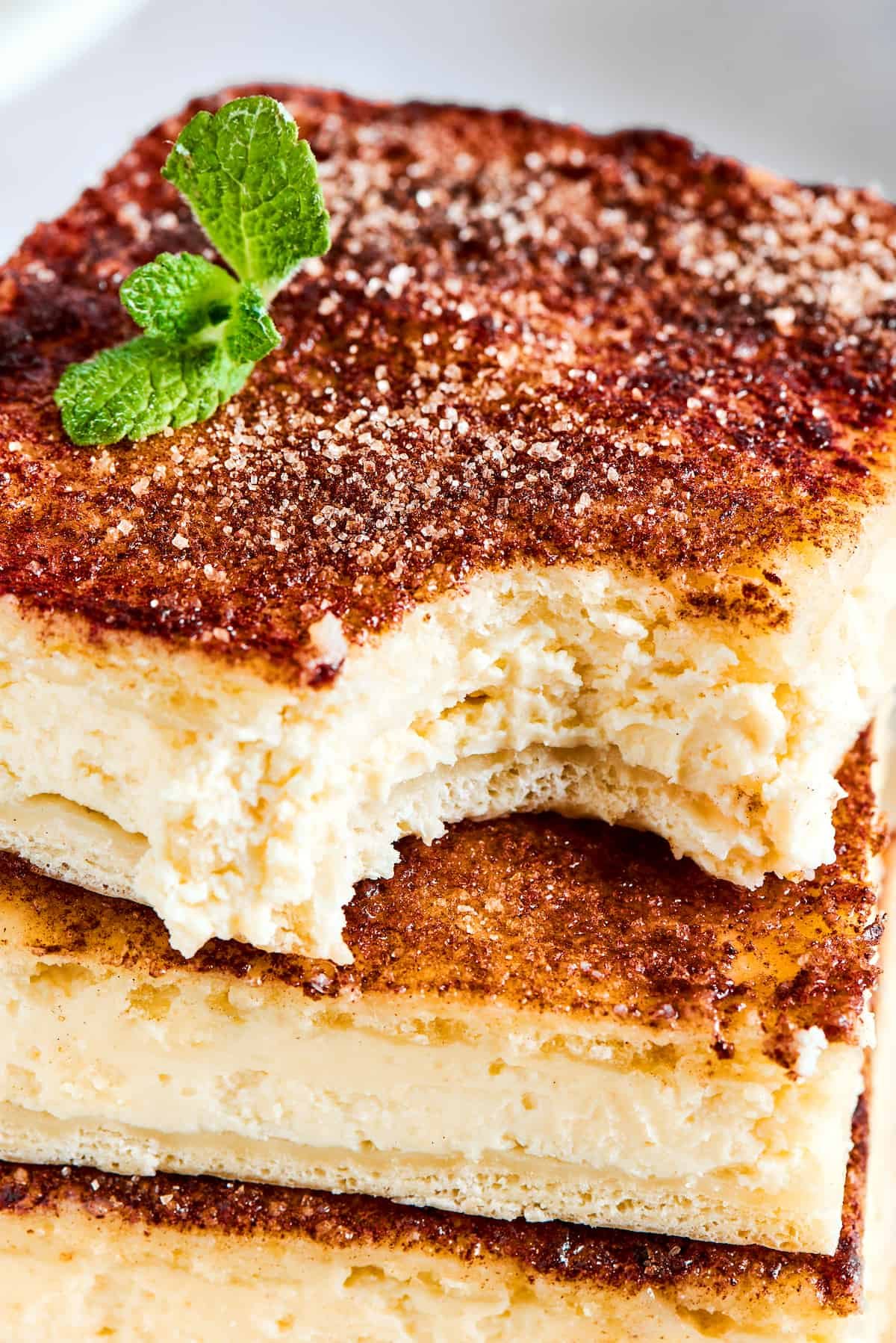 Close-up of cheesecake bars with a bite taken from the top bar.