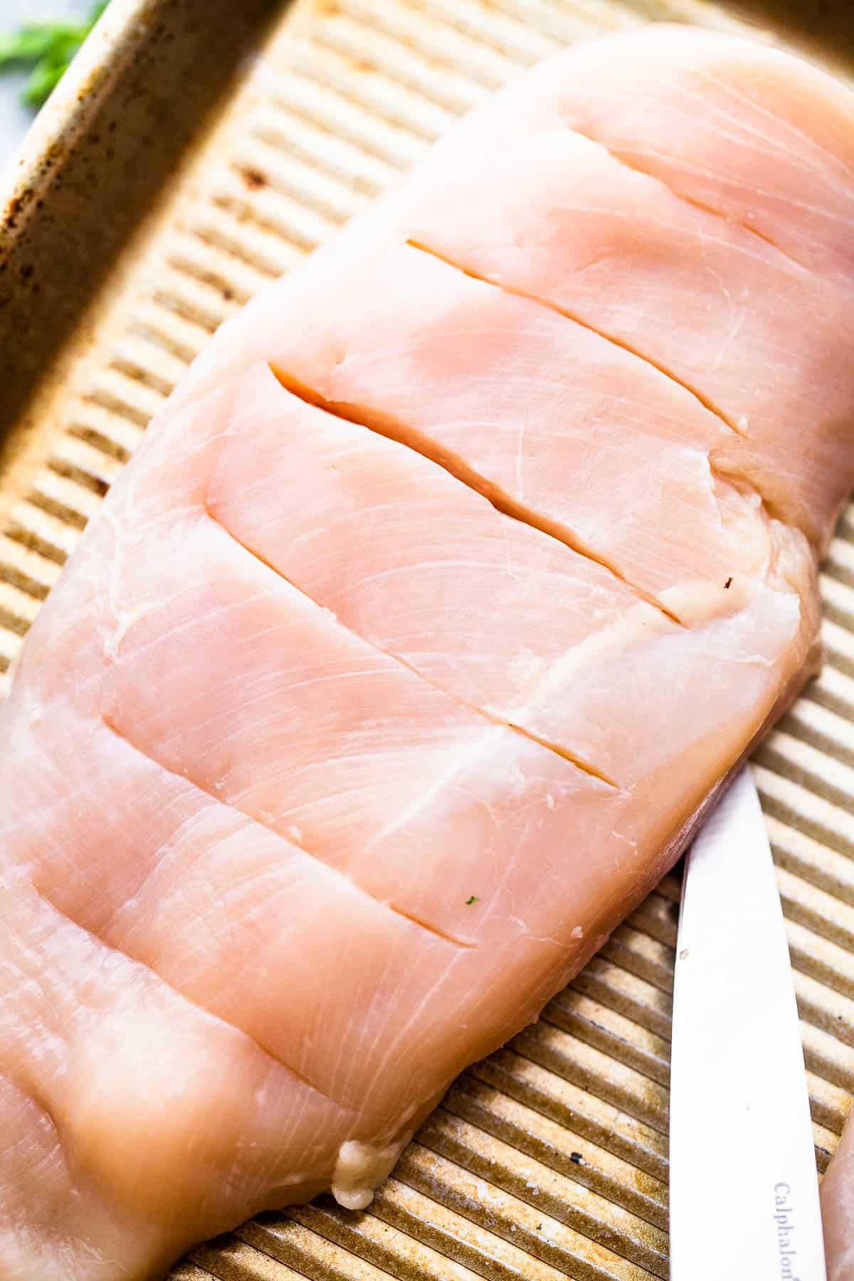 raw chicken breasts cut hasselback style