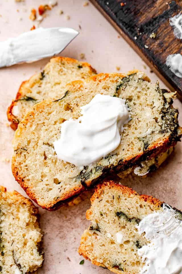 close up shot of spinach and feta cheese no yeast bread slice topped with yogurt
