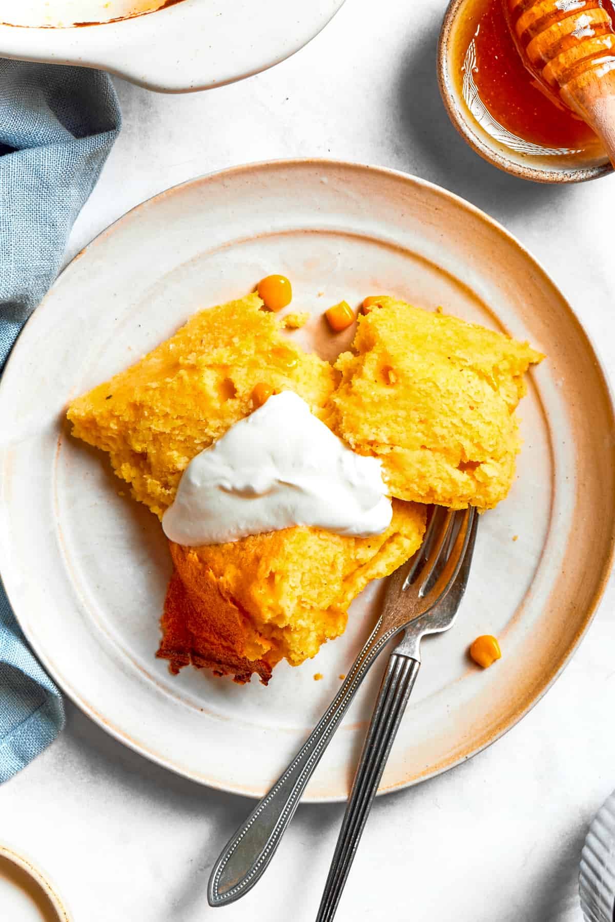 Spoon Bread served on a plate and topped with sour cream.