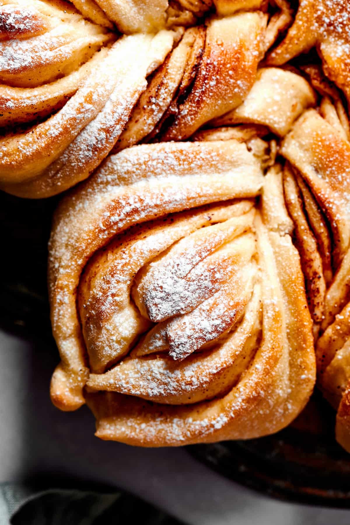 Close up overhead view of one segment of star bread, topped with powdered sugar.
