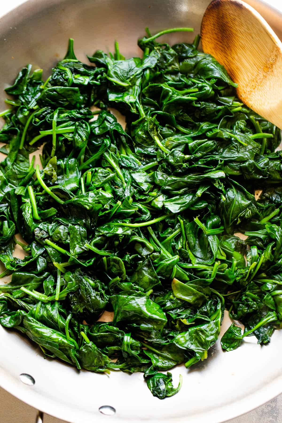 cooking spinach in stainless steel skillet