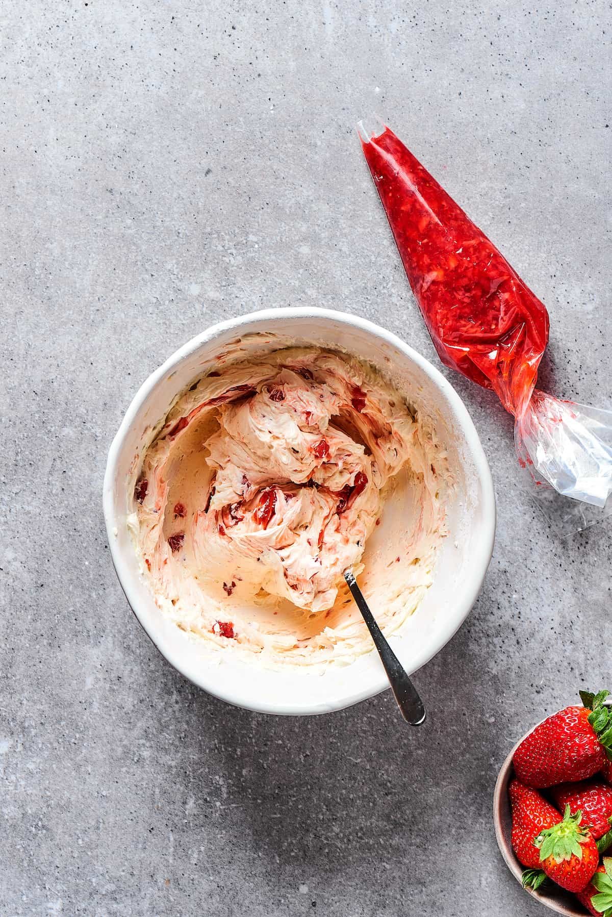 Strawberry frosting in a small bowl.