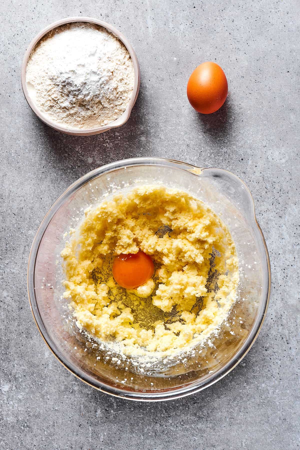 Beating eggs into creamed butter and sugar.