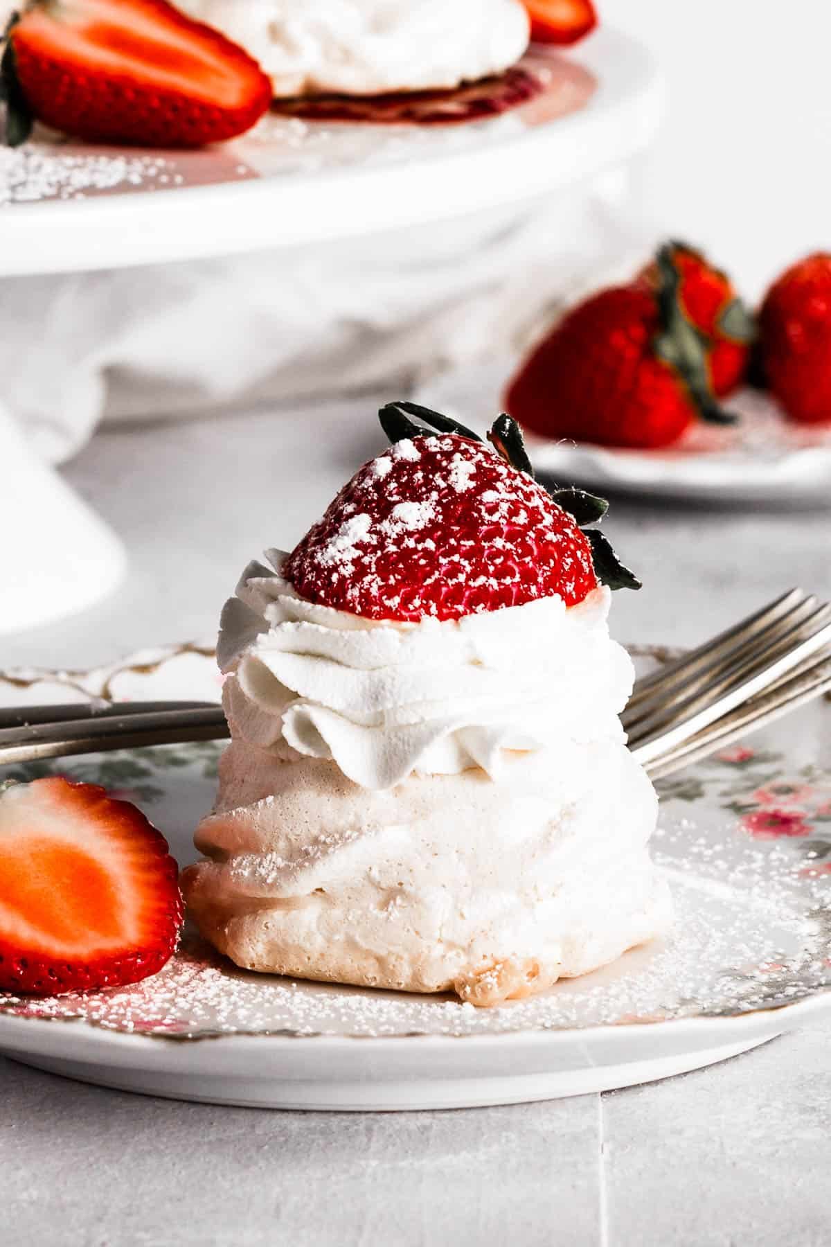 A mini pavlova on a plate with strawberries