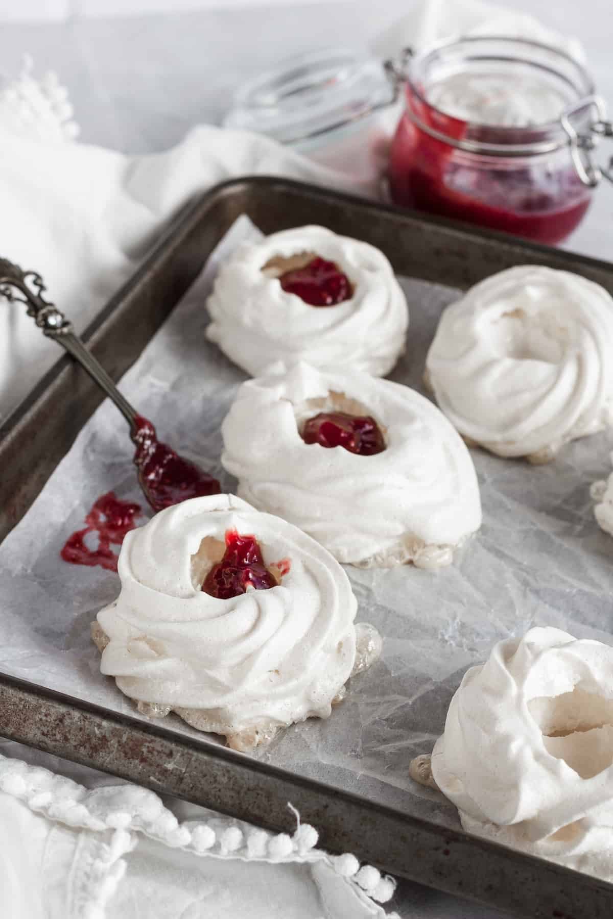 Pavlova nests being filled with strawberry filling