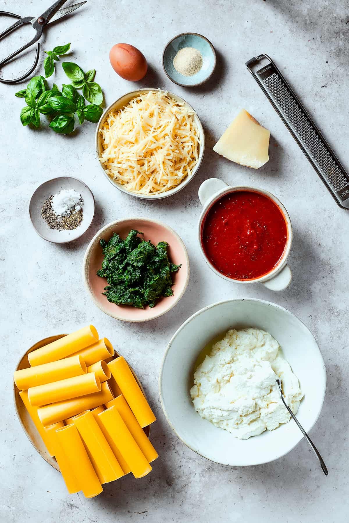 Stuffed manicotti ingredients arranged on a work surface.