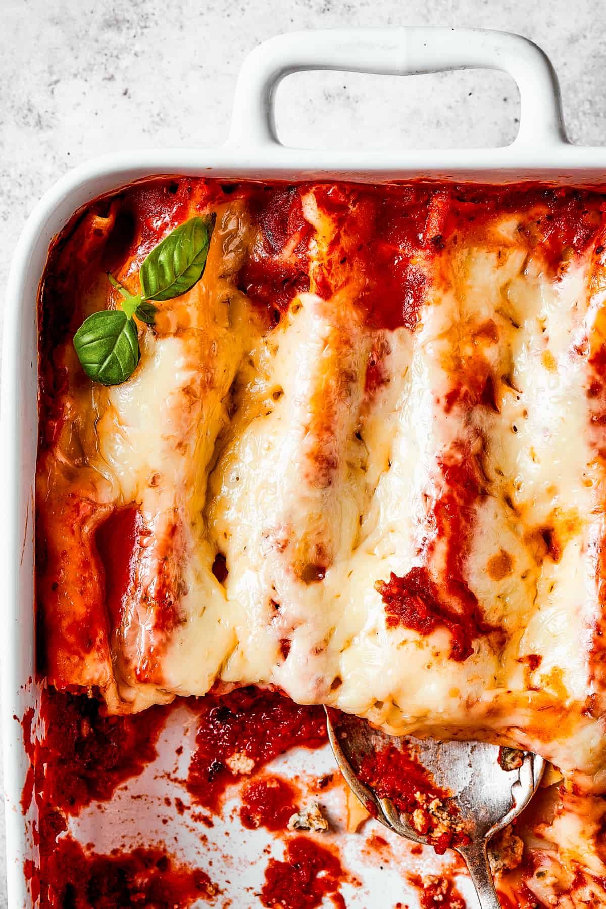Close-up of baked manicotti that has been cut into and served.