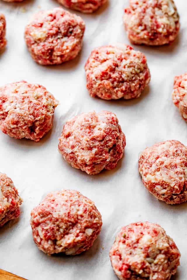 rolled up meatballs arranged on white parchment paper