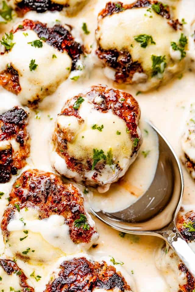 scooping out swedish meatballs drizzled with gravy