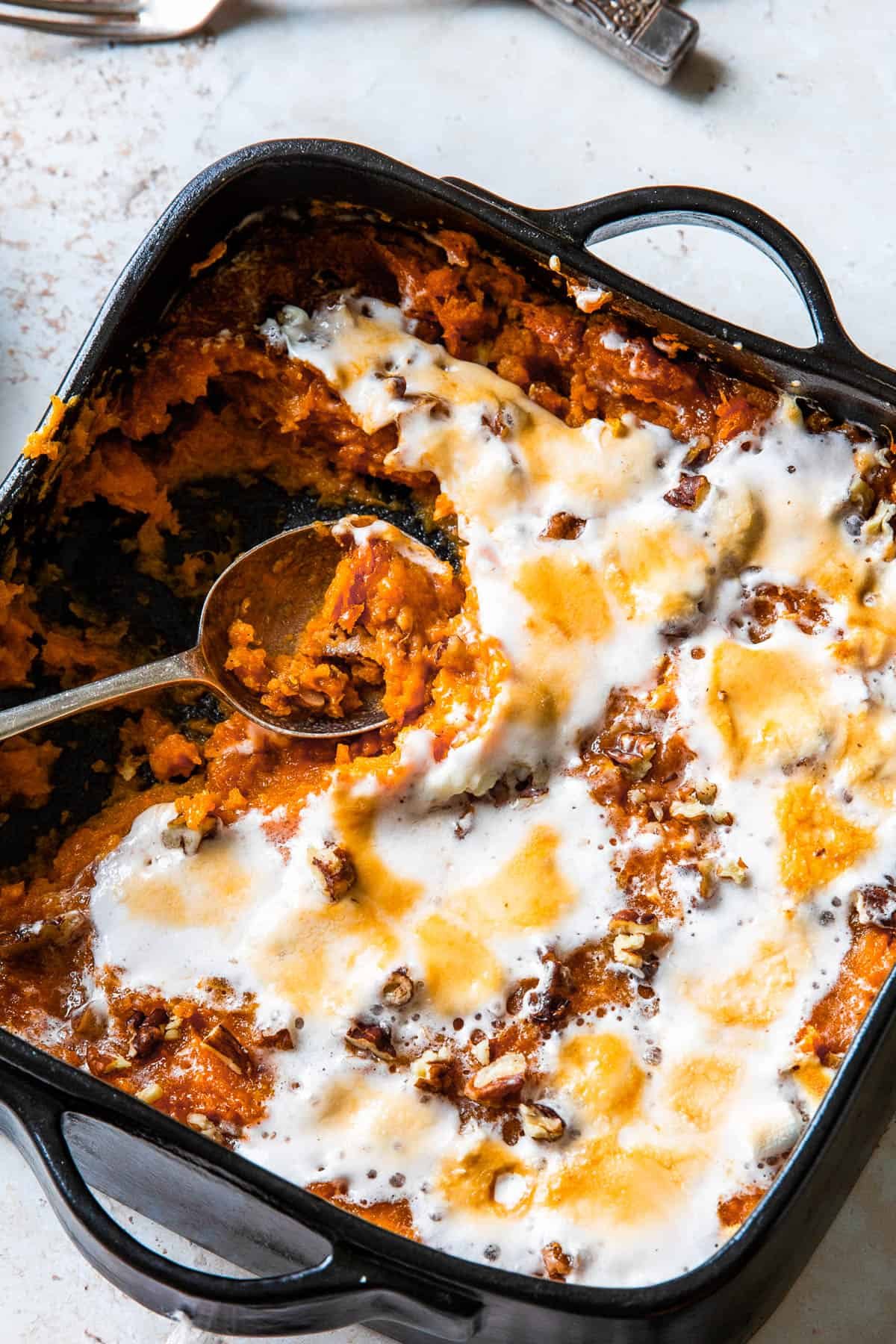 Sweet potato casserole with a spoon scooping out a portion.