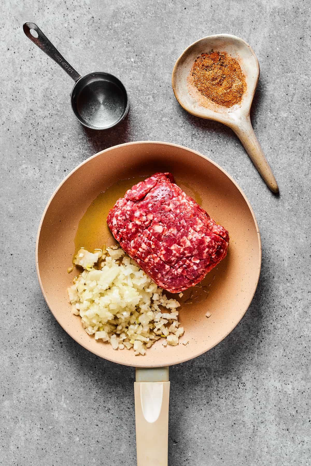 Cooking onion and ground beef in a skillet.