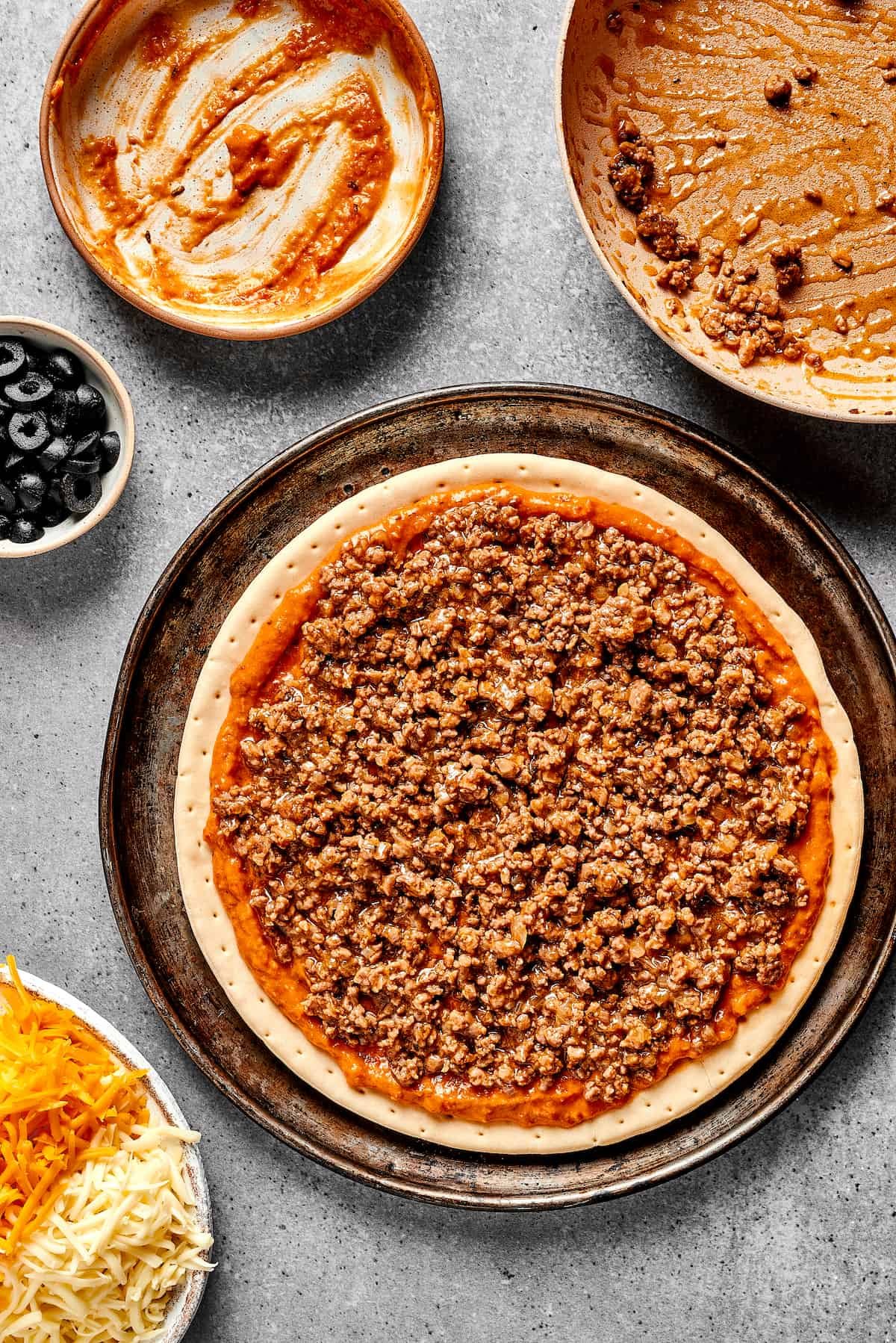 Beans, salsa, and meat on a pizza crust.