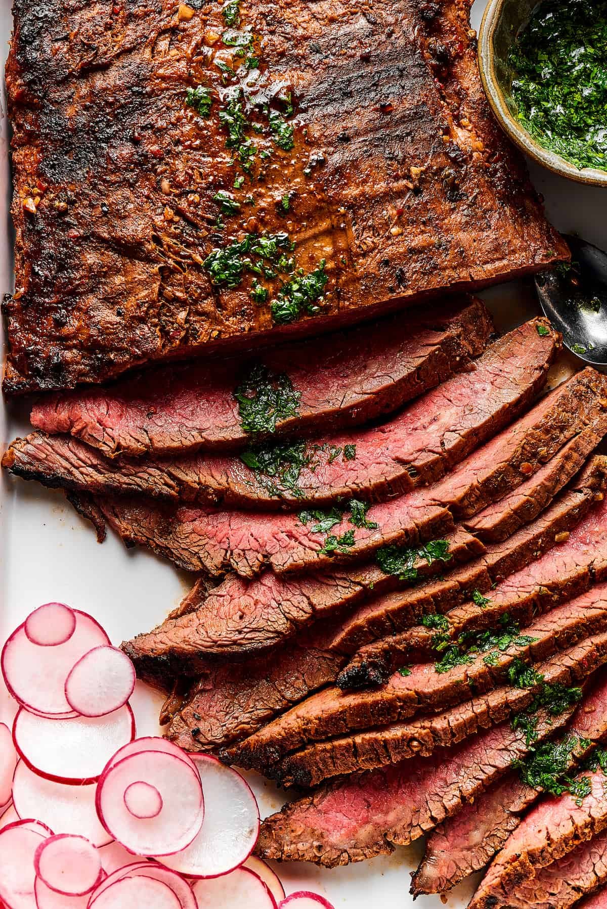 Thinly sliced grilled carne asada on a serving platter.
