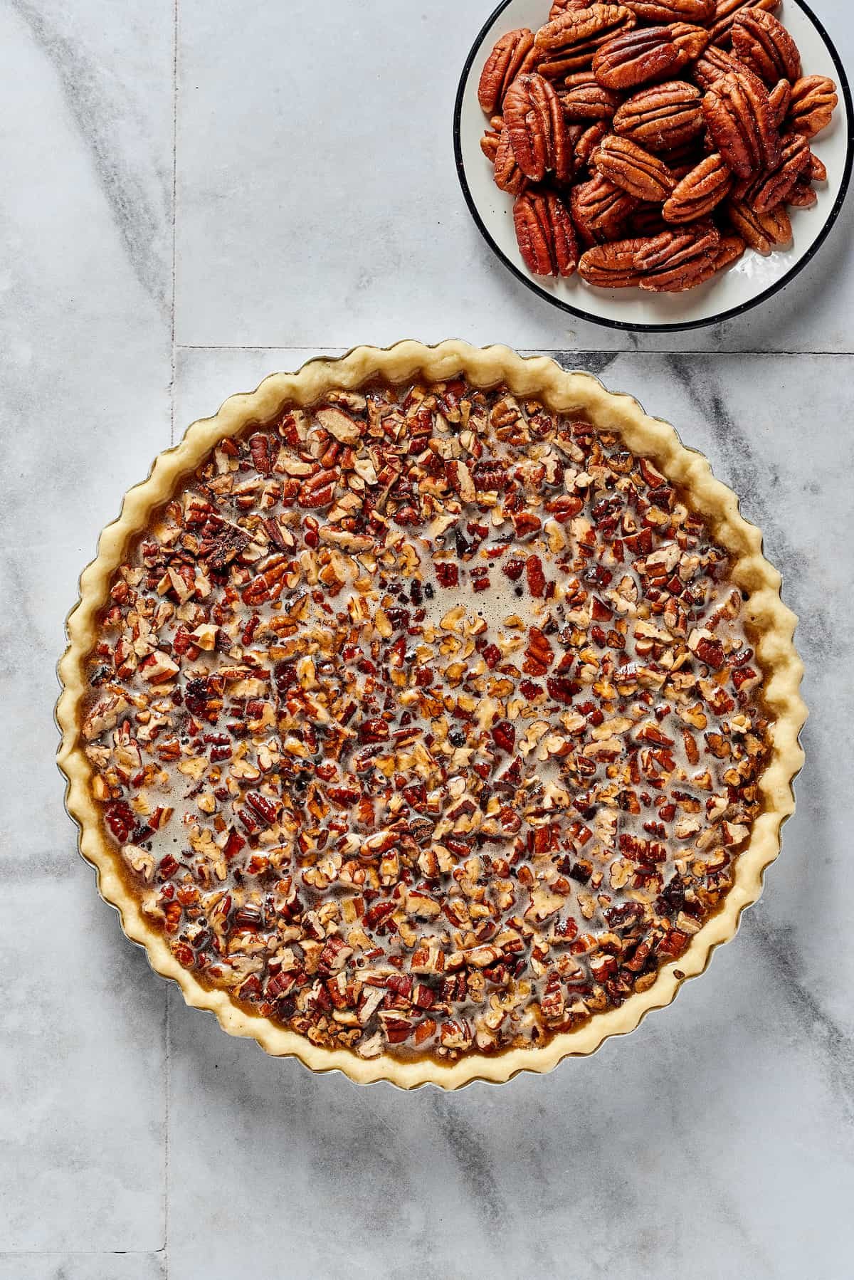 Overhead shot of a partially-assembled pecan pie. The pecan halves have not yet been added.