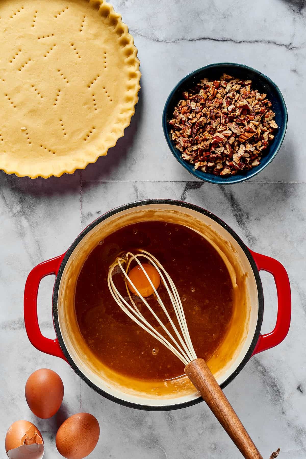 Beating eggs into cooled maple syrup mixture.